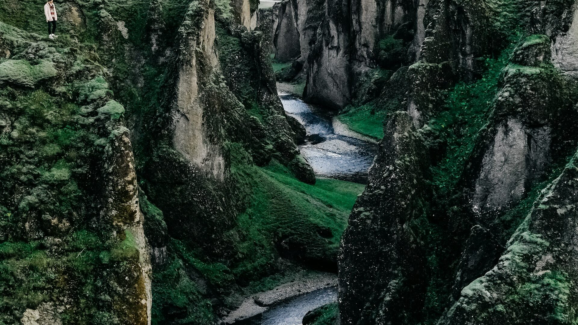 Glacial river braiding across black volcanic sand in Iceland, seen from above