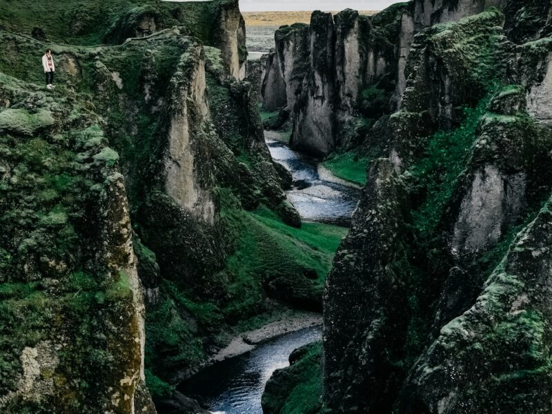 Glacial river braiding across black volcanic sand in Iceland, seen from above